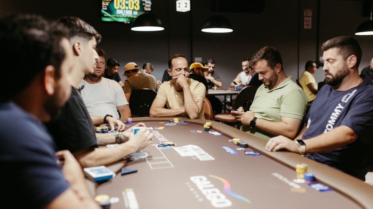Group of men playing an intense poker game in a modern casino setting with focus on strategy.