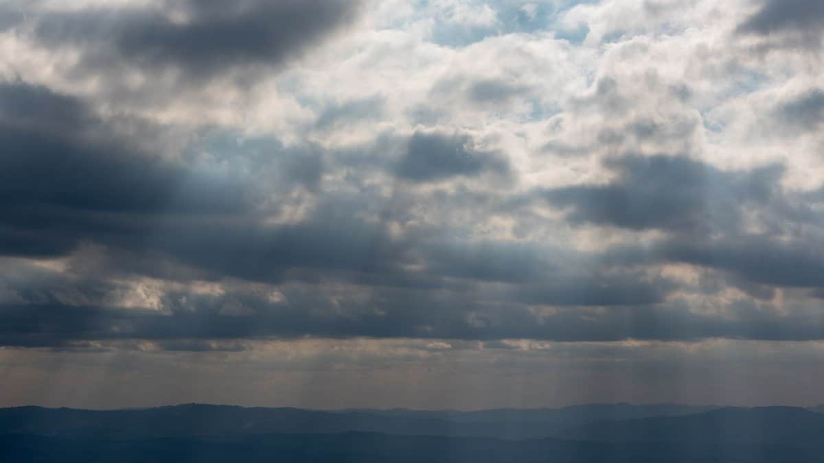 A dramatic sky with diffused clouds over the hills of Minas Gerais, Brasil, at dusk.