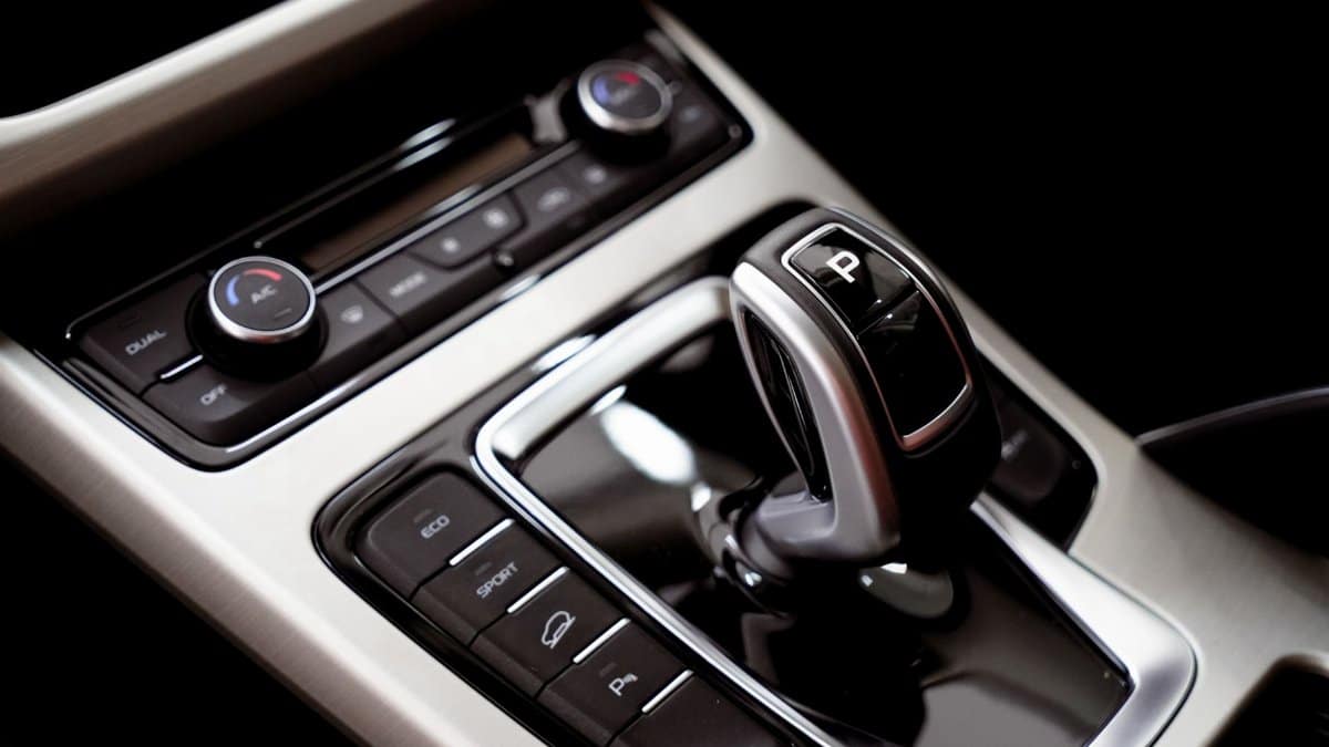 Close-up of a car's modern gear shift and central console with buttons.