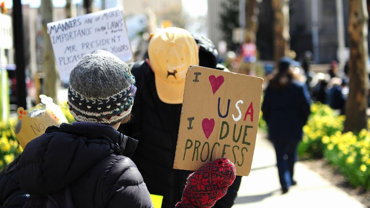 Protesters in Baltimore hold signs promoting due process and justice in a peaceful demonstration.