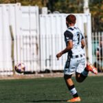 A young soccer player in action on a sunny day outdoors.
