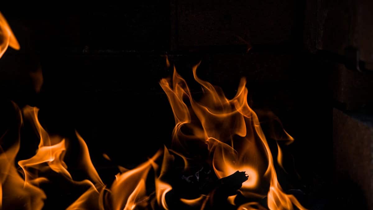 Capturing the vivid dance of orange flames in a dark fireplace setting.