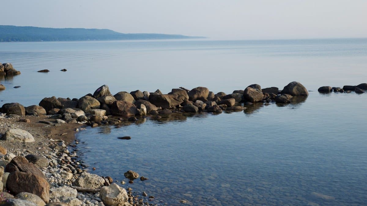 Peaceful rocky shoreline by the calm sea, perfect for relaxation or meditation.