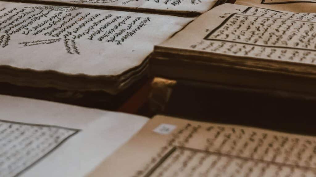 A collection of ancient manuscripts featuring Arabic script, showcasing historical texts on aged paper.