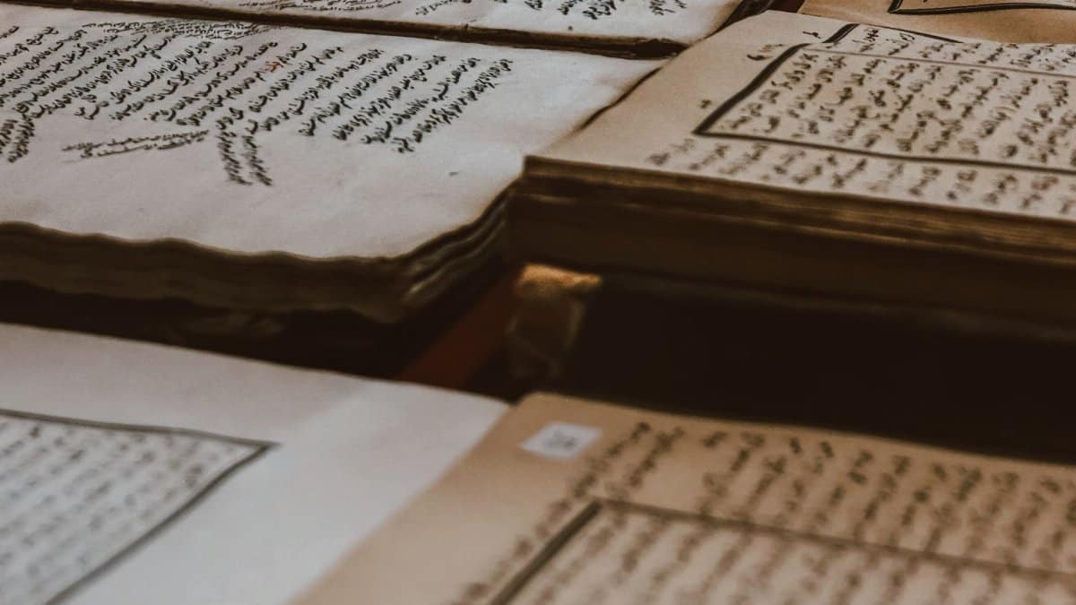 A collection of ancient manuscripts featuring Arabic script, showcasing historical texts on aged paper.