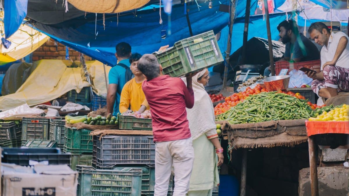 A vibrant market scene showing vendors and shoppers, surrounded by fresh produce and colorful stalls.