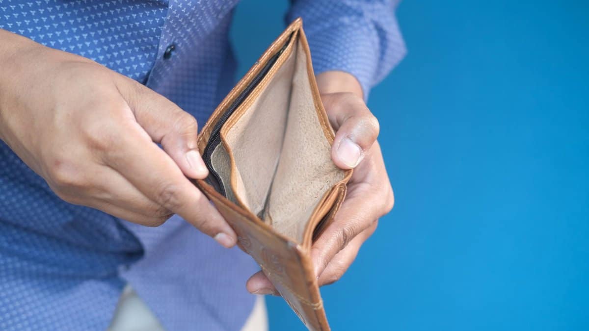 Close-up of hands holding an empty wallet, symbolizing financial challenges.