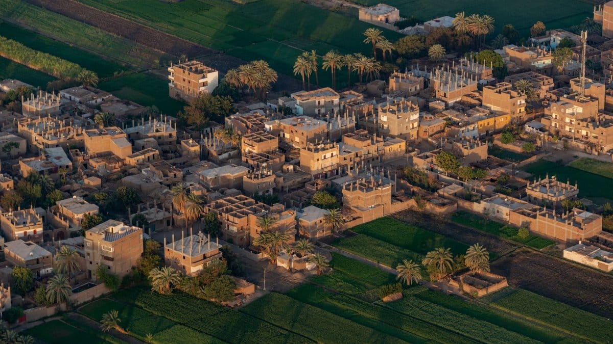Aerial photo of a rural town surrounded by lush fields and palms.