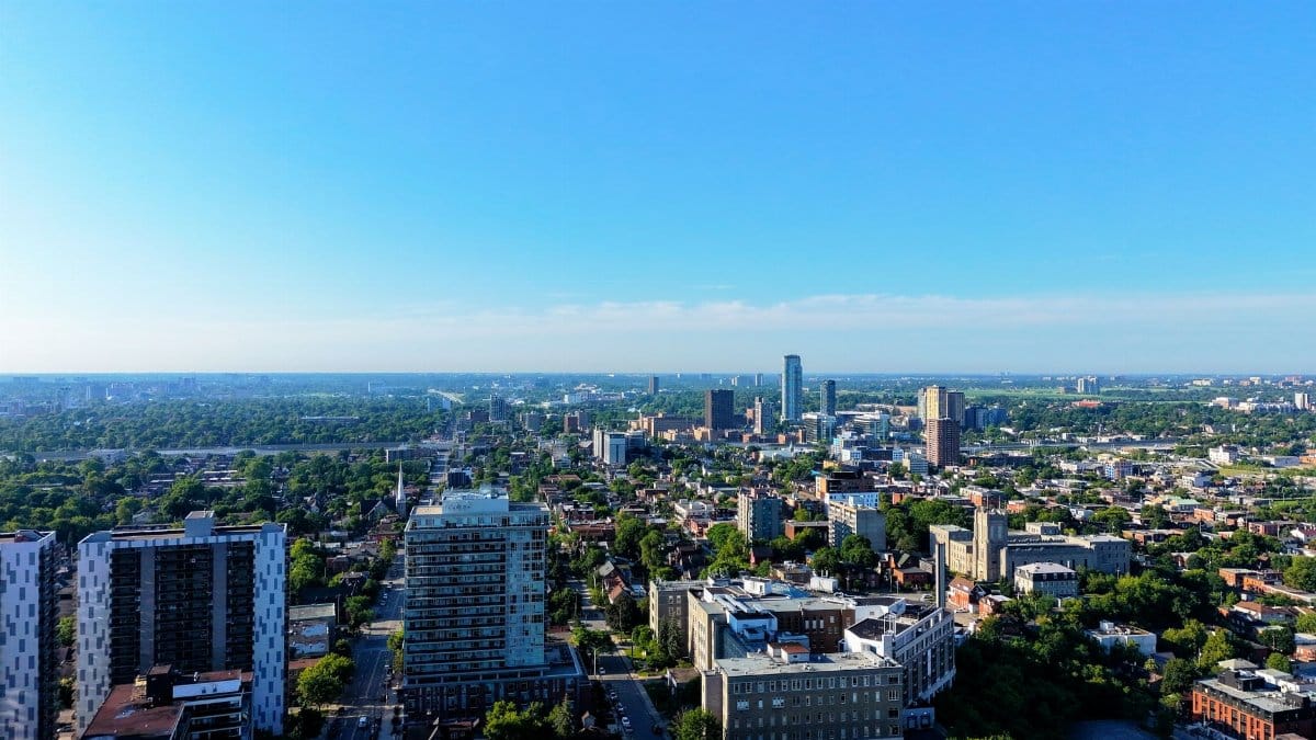A vibrant aerial view of Toronto cityscape showcasing skyscrapers and urban greenery under a clear blue sky.