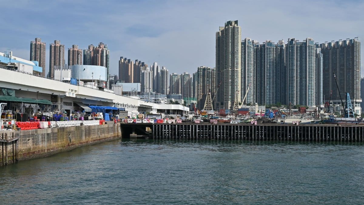 High-rise buildings and waterfront view in a busy harbor area under a bright day sky.