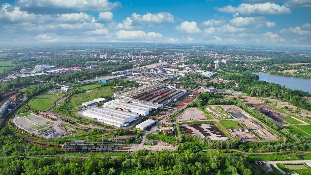 Drone view of Bohumín, showcasing industrial areas and green landscapes under a bright sky.