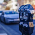 Close-up of parking meters in a bustling city street during the day, showcasing urban infrastructure.