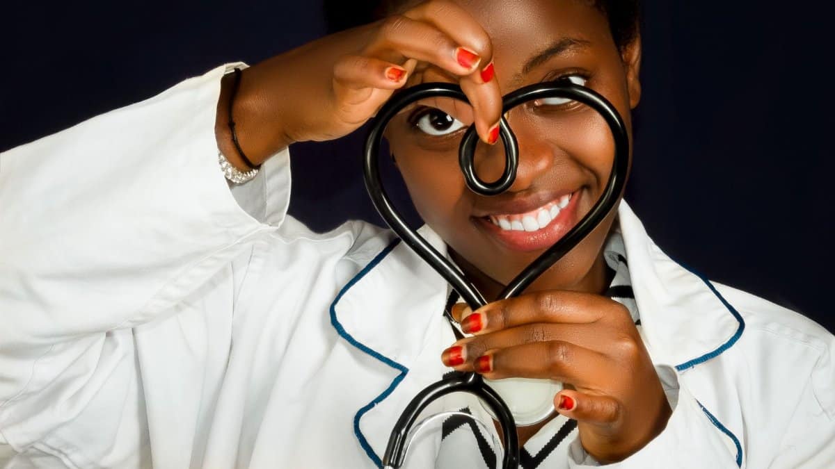Smiling female doctor with a stethoscope shaped as a heart signifying care and compassion.