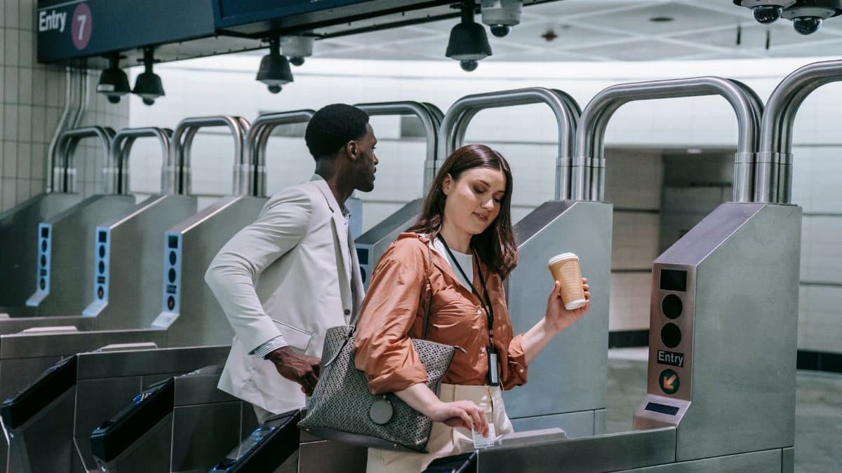 Diverse commuters with coffee entering subway turnstiles, symbolizing urban daily commute.