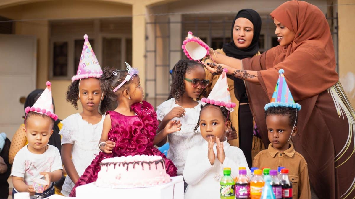 Happy children at a colorful outdoor birthday party enjoying cake and fun.