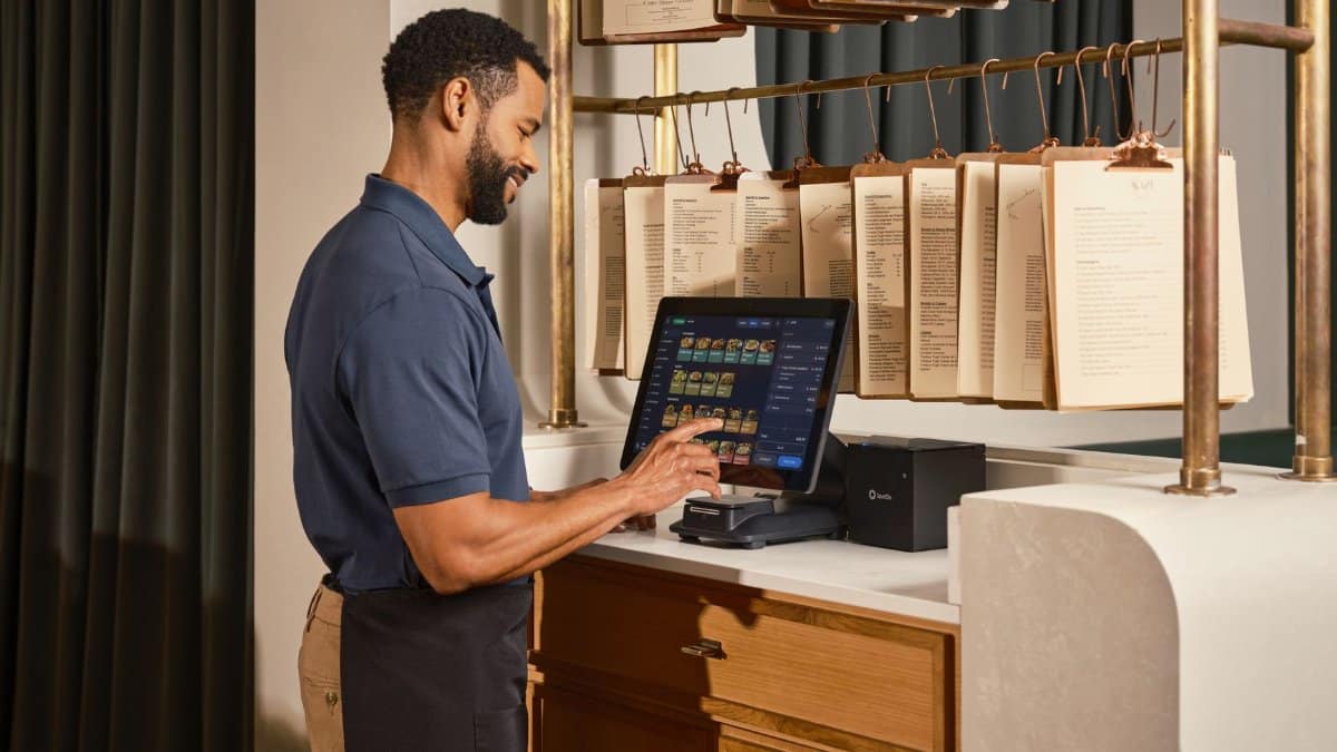 A restaurant server operates a touchscreen POS system, enhancing efficient order management.