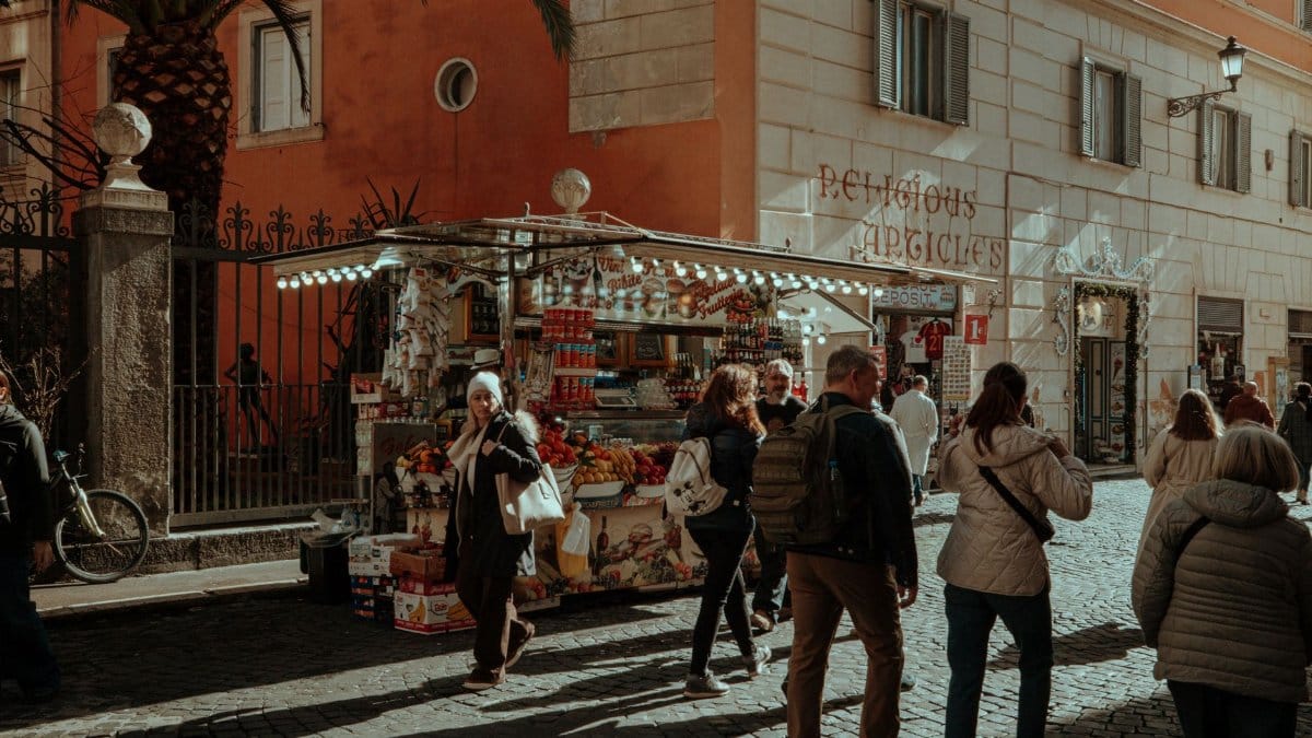 A bustling outdoor street market scene in a European city, capturing daily life.