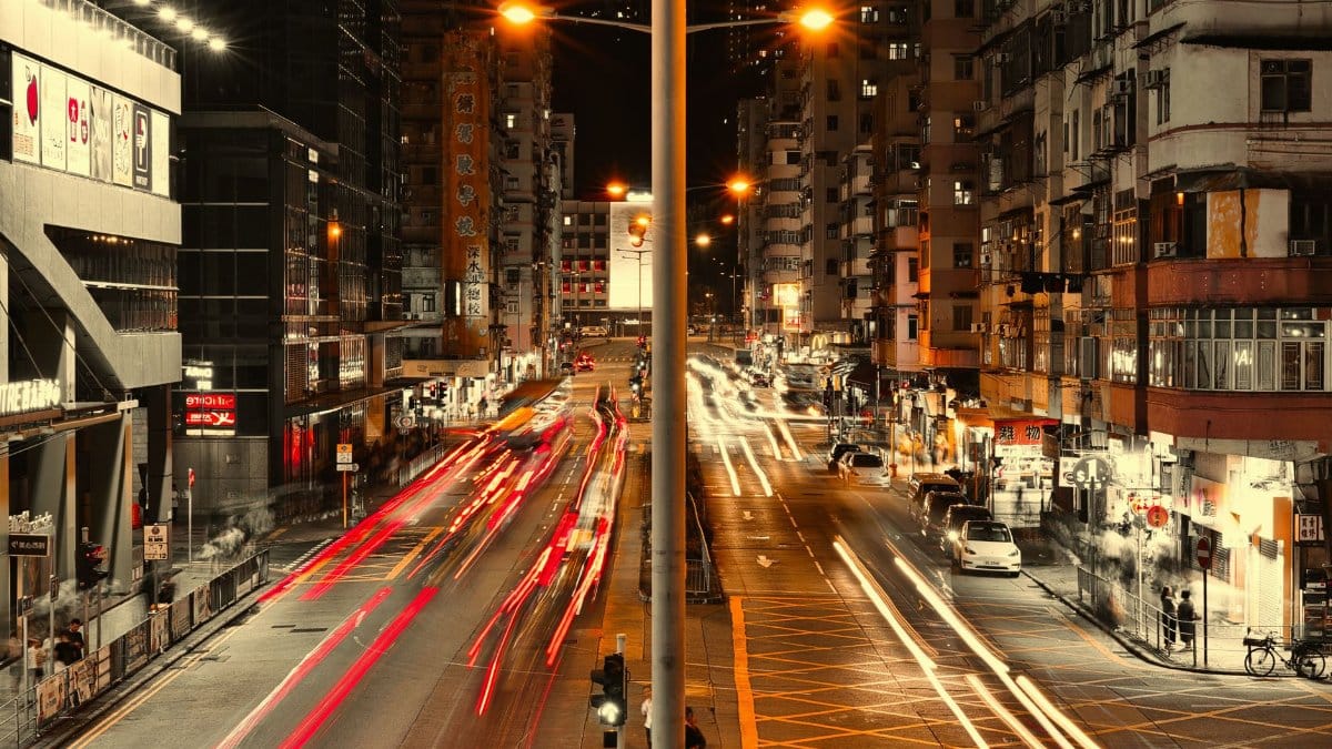 Vivid night cityscape showcasing urban streets with light trails and illuminated buildings.