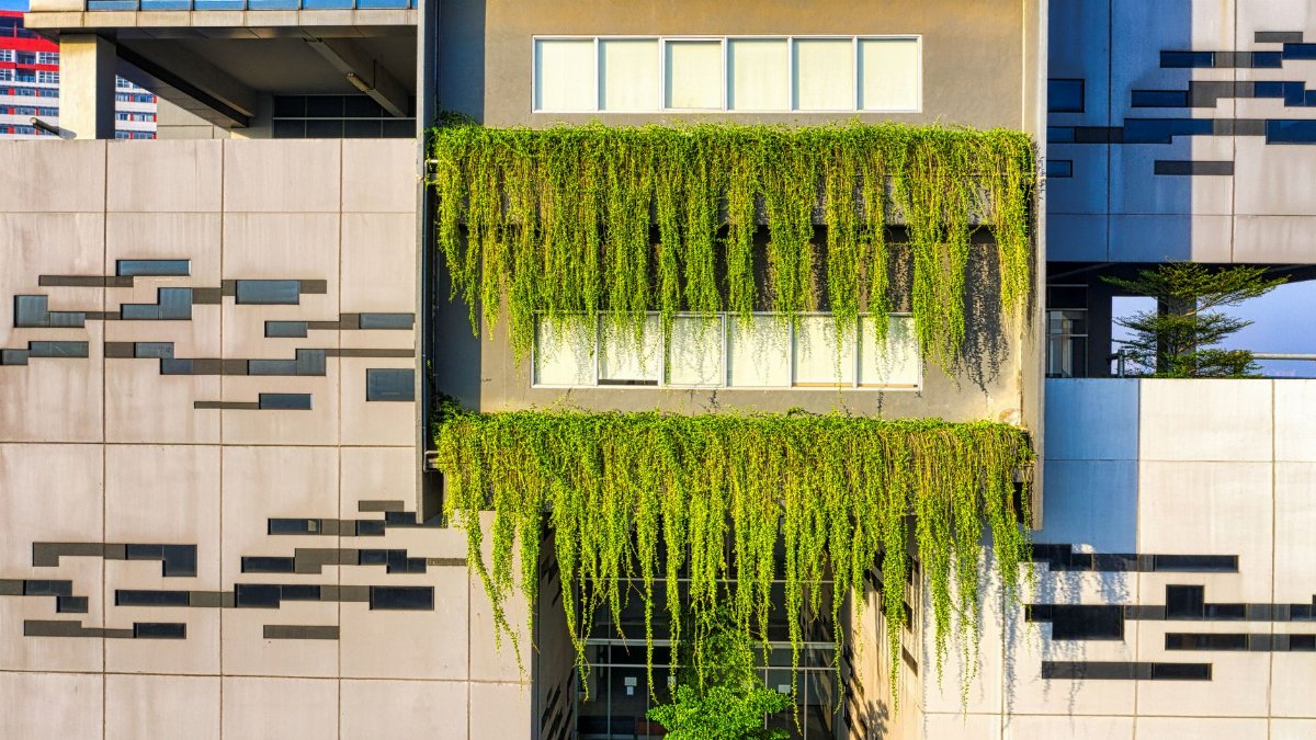 Contemporary building facade with lush green plants in urban Banten, Indonesia.