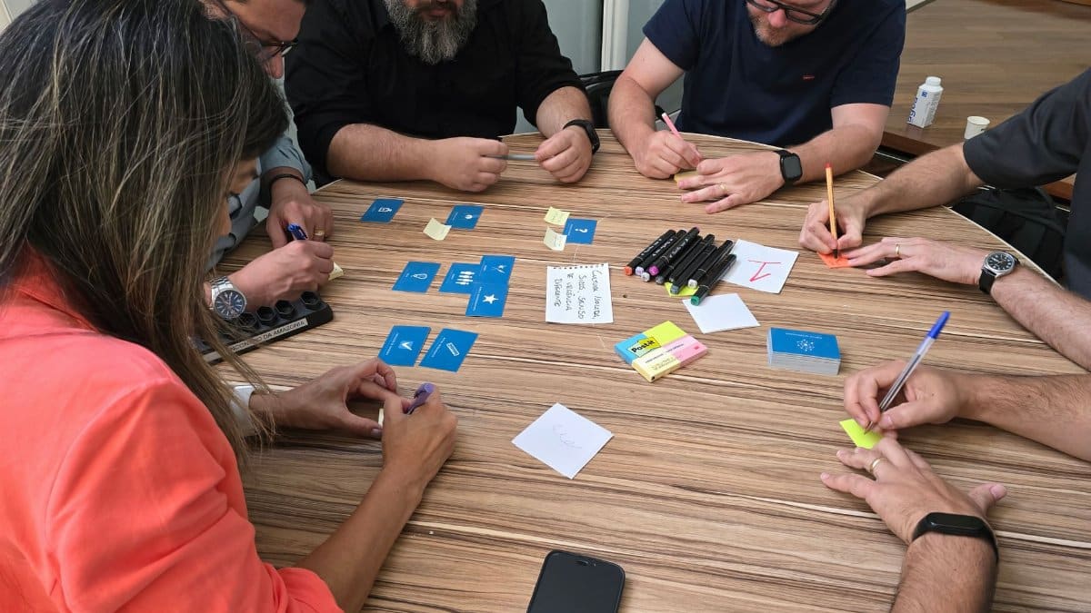 Diverse team engaged in a brainstorming session with cards and sticky notes on a round table.