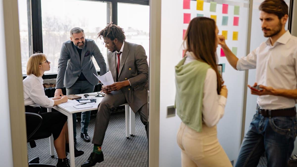 Office environment with diverse team members brainstorming and collaborating on a project.