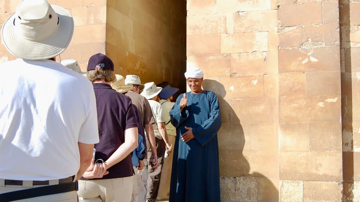 A local guide gives a thumbs up to tourists at a historic site in Cairo, Egypt.