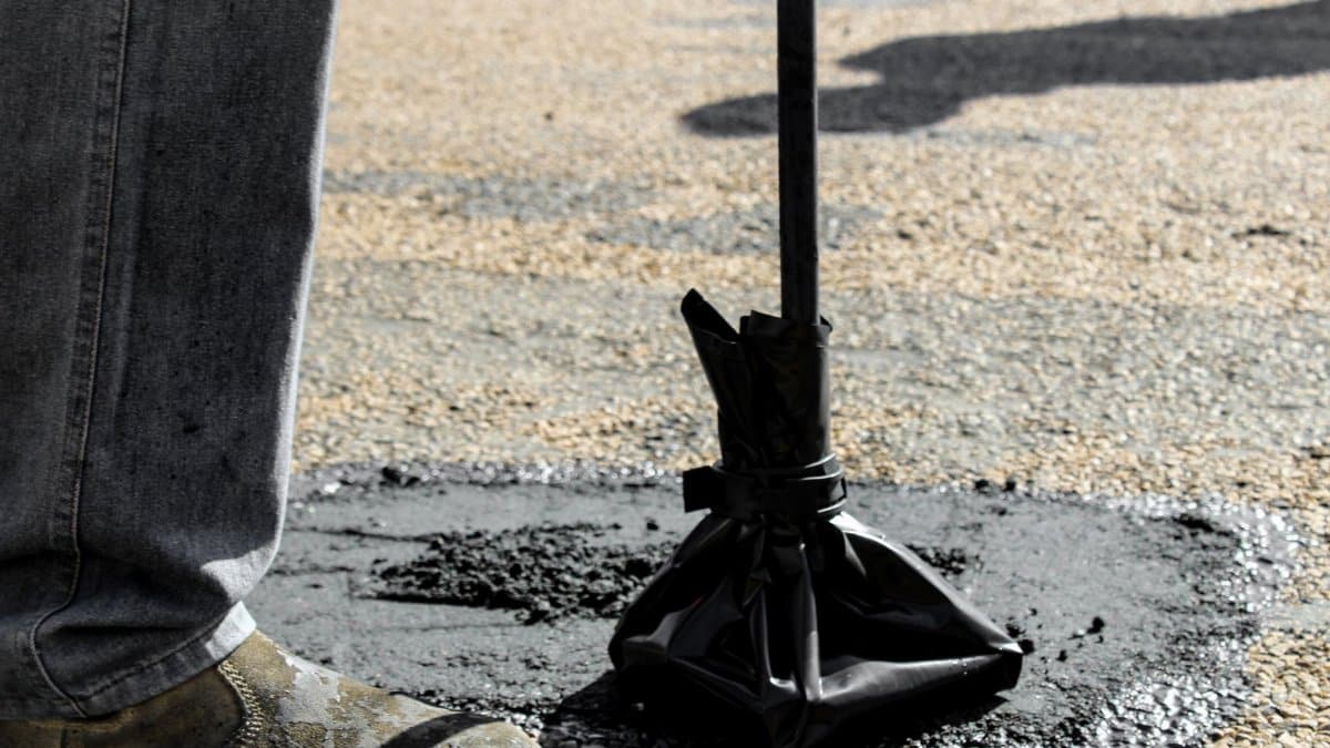 Close-up of road repair work in South Africa, featuring asphalt patching tools.
