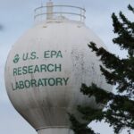 U.S. EPA Research Laboratory water tower with trees in view.