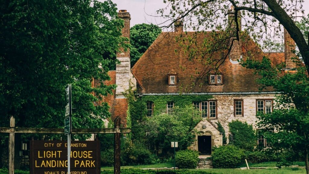 Charming stone house with ivy-covered walls in a lush garden at Lighthouse Landing Park, Evanston.
