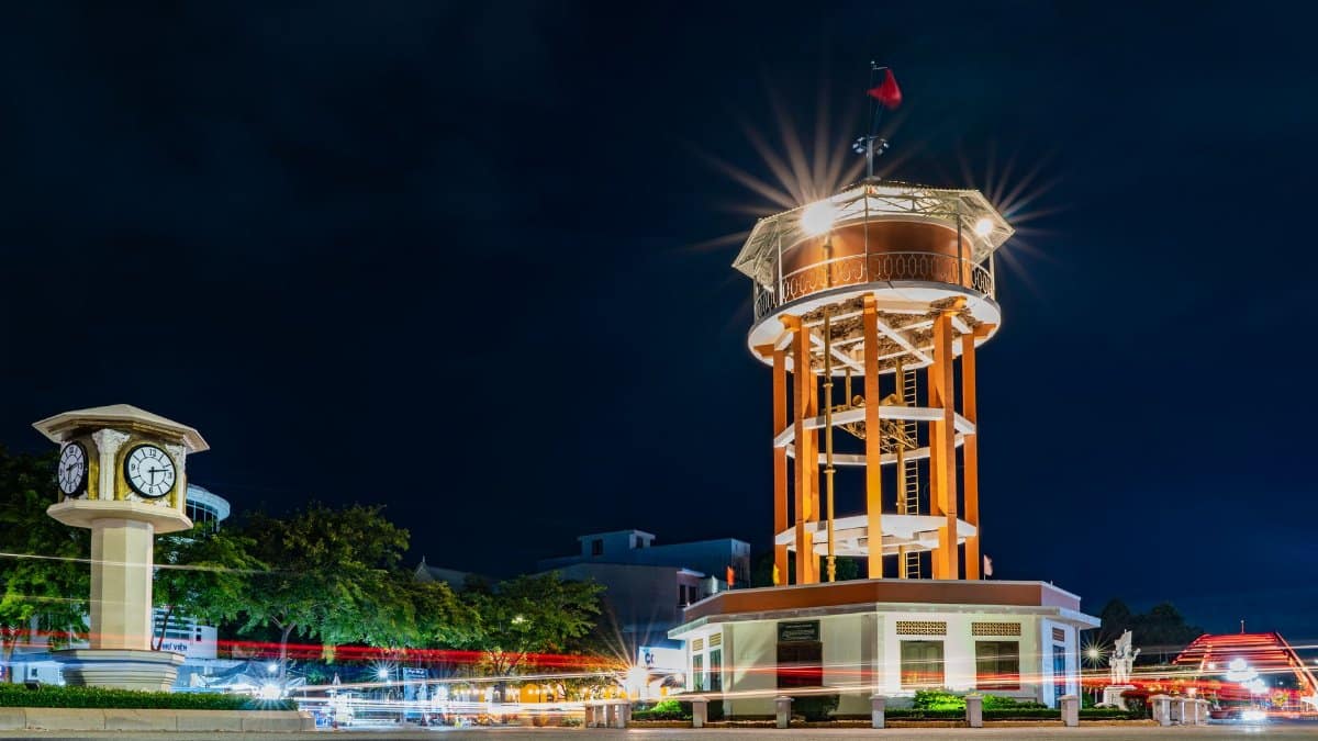 A stunning night view of the iconic tower and clock in Bà Rịa, Vietnam, captured with vibrant city lights.