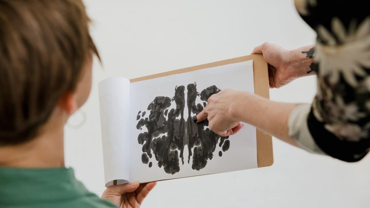 A psychologist and patient discuss a Rorschach inkblot test during a therapy session.