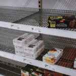 Image of partially empty grocery shelves in Sydney highlighting food scarcity.