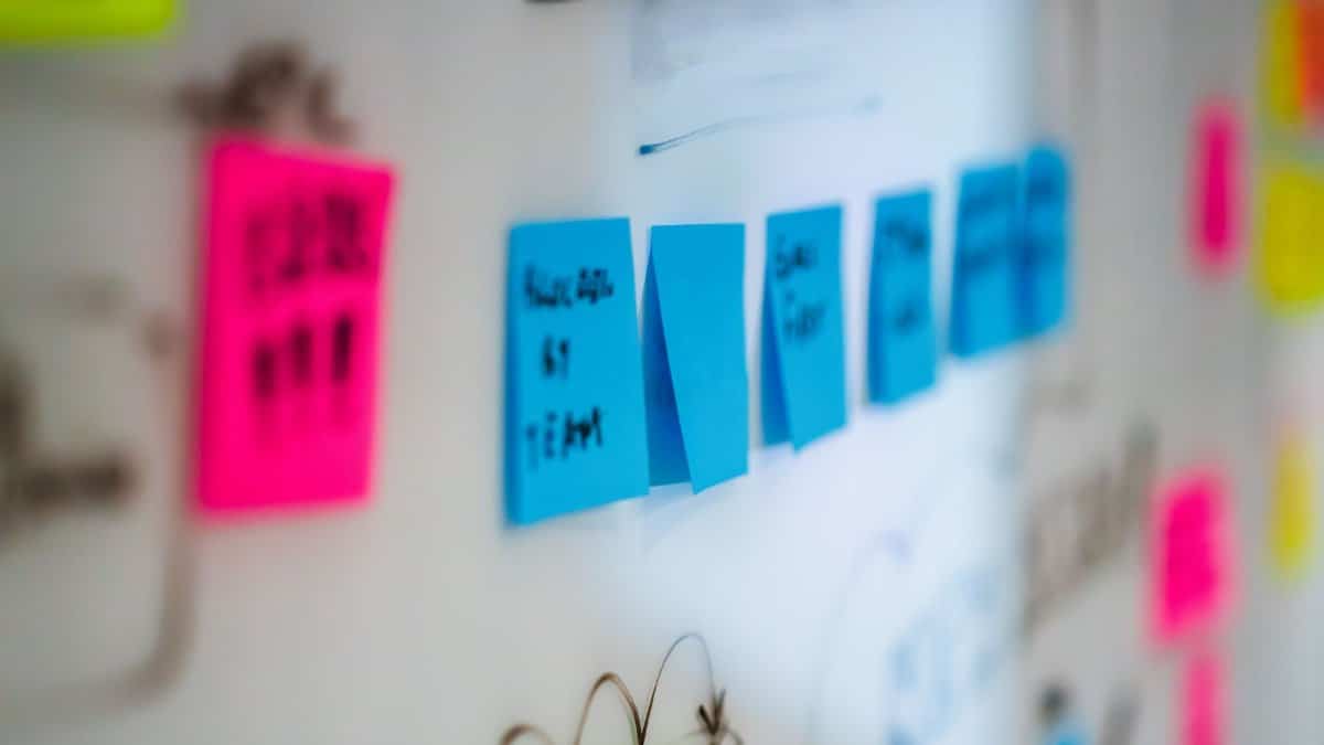 Sticky notes on a whiteboard during a creative brainstorming session in an office.