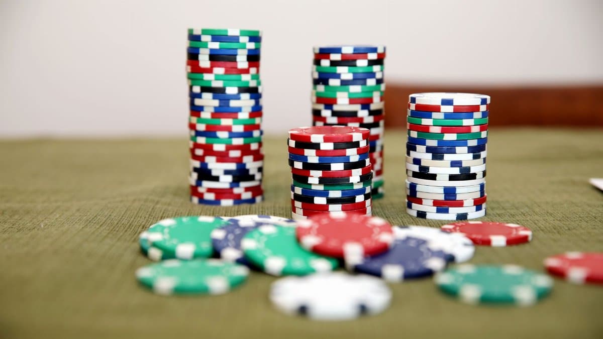 Stacks of colorful poker chips on a green table ready for a game.