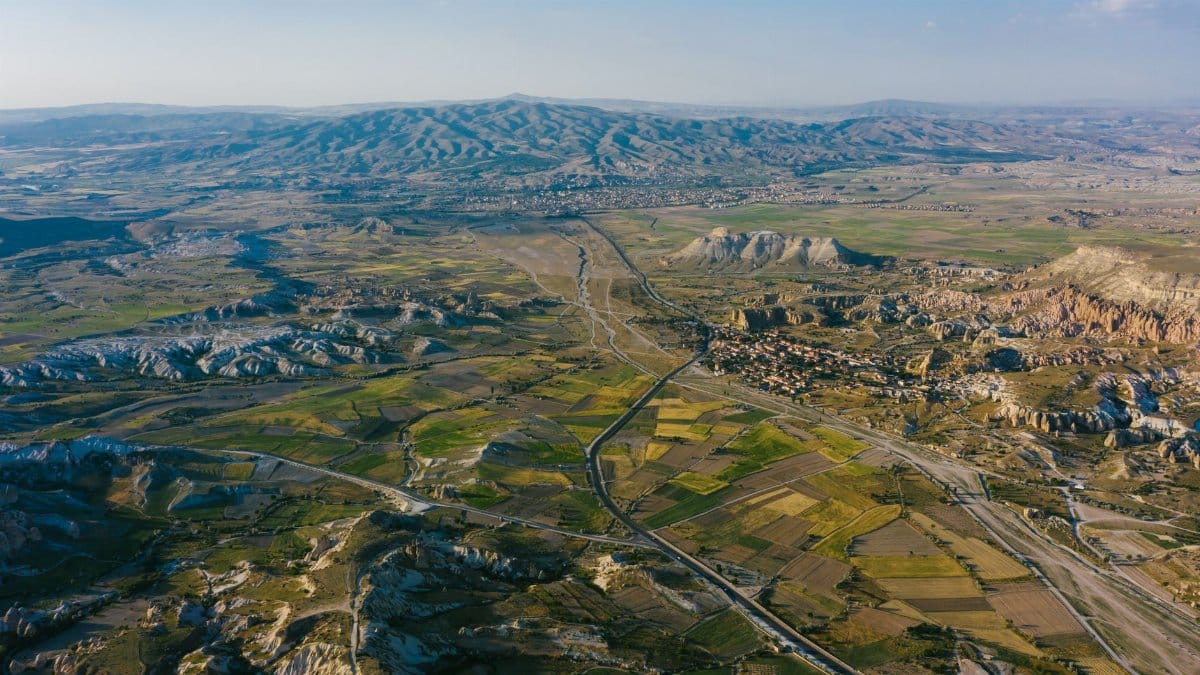Stunning aerial view of Cappadocia's unique terrain featuring rock formations and fields.