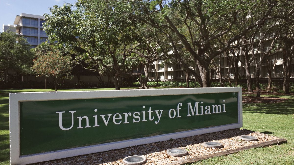Outdoor view of the University of Miami entrance with lush greenery during the day.
