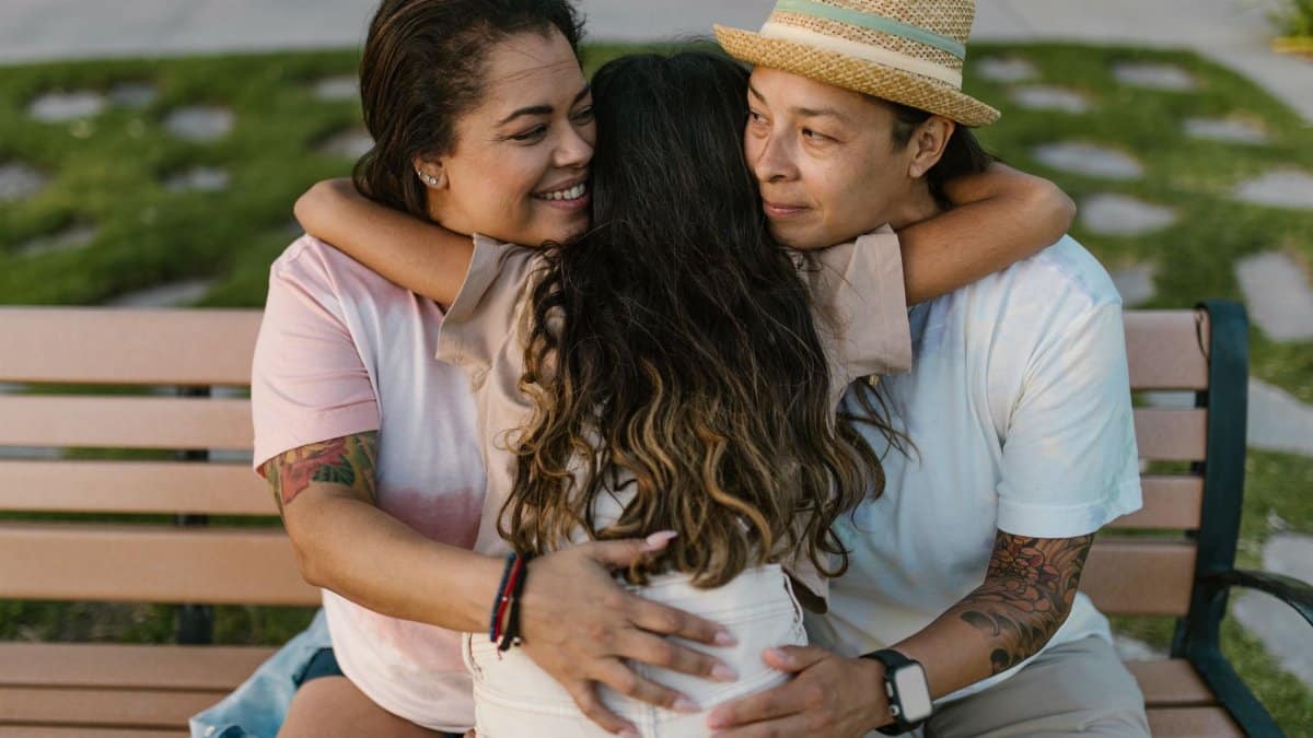 A heartwarming moment of a family hugging on a park bench, showcasing love and togetherness.