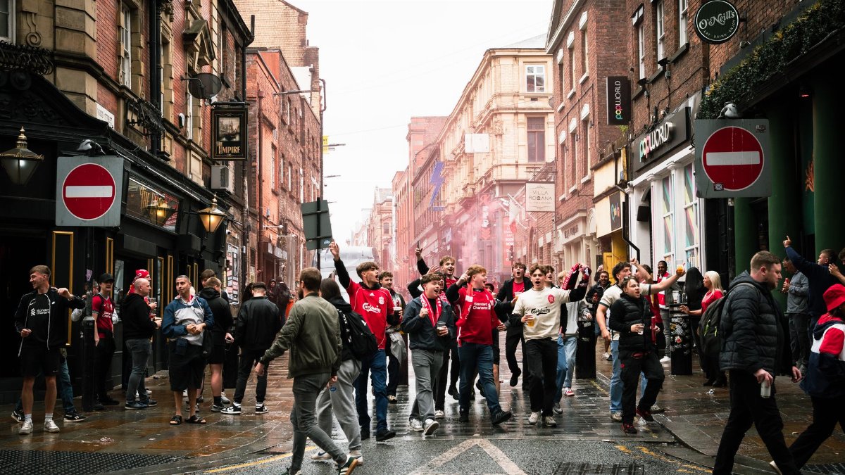 A vibrant street scene of football fans celebrating in Liverpool, England.