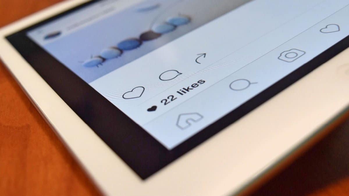 Photo of a tablet displaying a social media app interface with 22 likes, highlighting digital interaction.