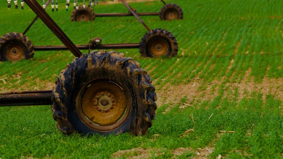 Detailed view of agricultural irrigation system wheels on a green farm field.