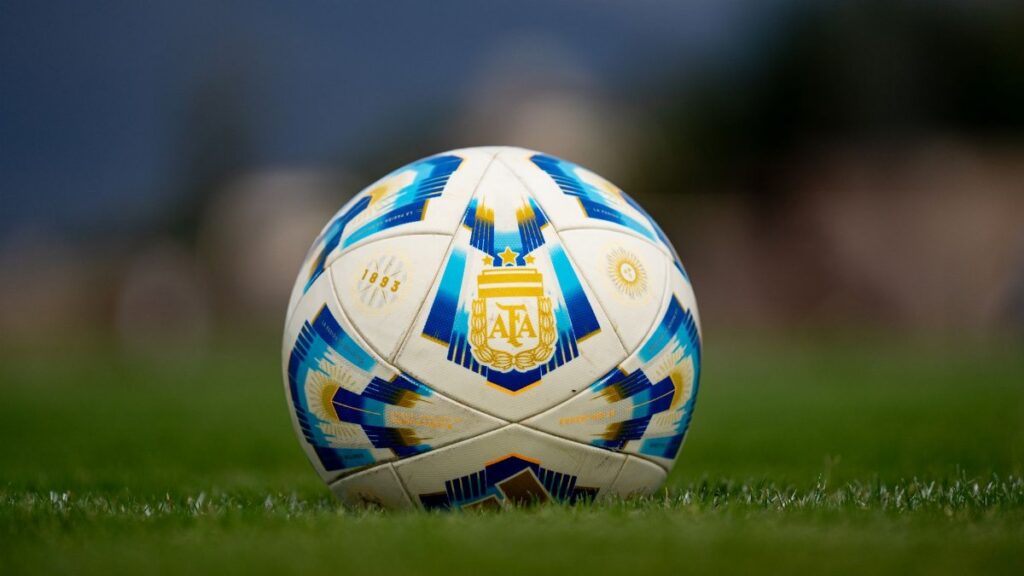 Detailed view of a soccer ball with AFA logo on a green field.