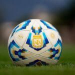 Detailed view of a soccer ball with AFA logo on a green field.