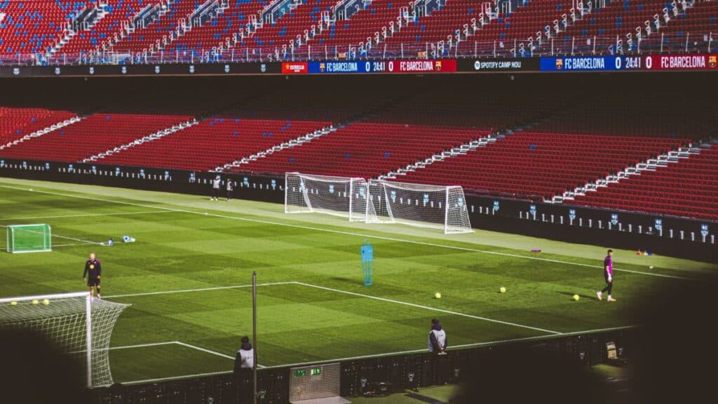 View of empty soccer field at FC Barcelona's Camp Nou with training equipment.