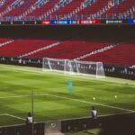 View of empty soccer field at FC Barcelona's Camp Nou with training equipment.