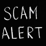 Blackboard with 'Scam Alert' written in white chalk, emphasizing a warning concept.