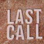 A top view of wooden letters spelling 'Last Call' on a textured brown surface.