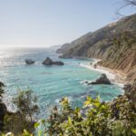 Experience the breathtaking coastal landscape of Big Sur with turquoise waters and lush greenery.