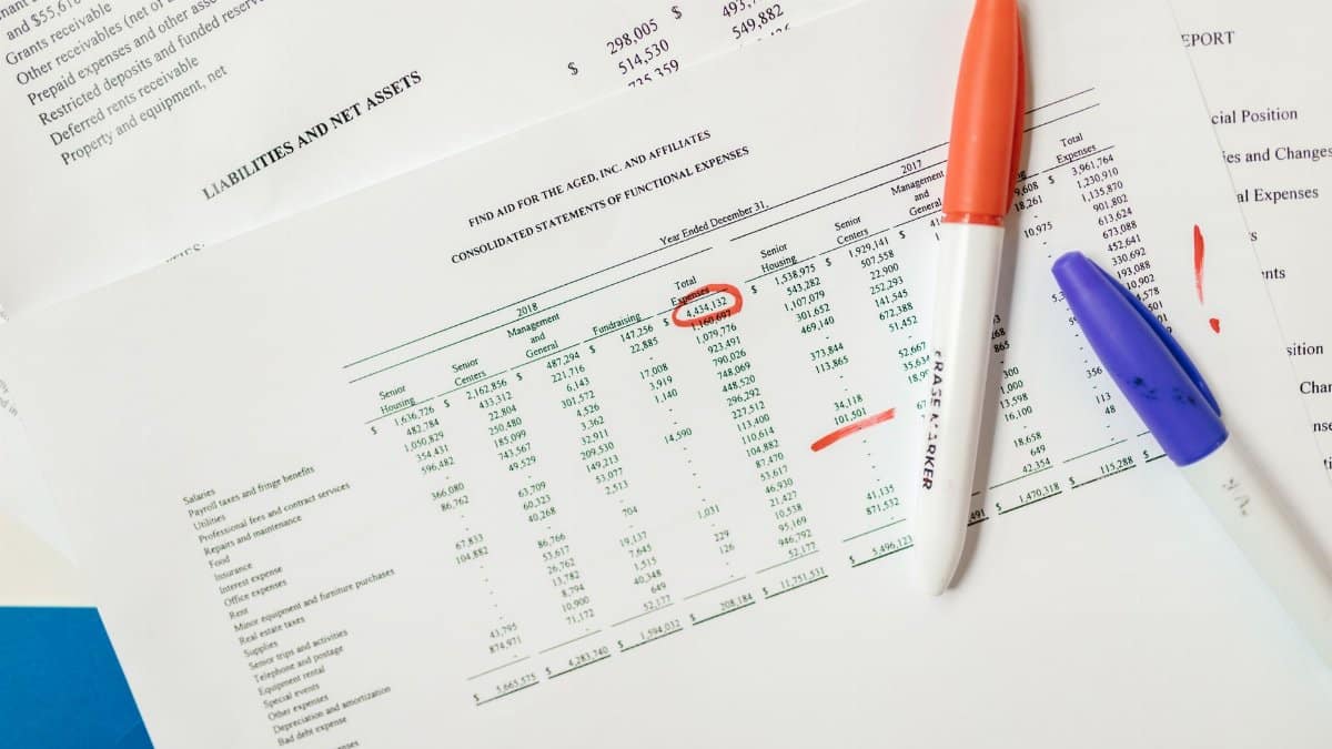 Close-up of financial documents with highlighted figures and marker pens.