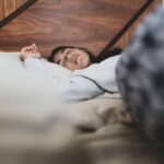 A woman peacefully sleeping on a bed, conveying relaxation and comfort.