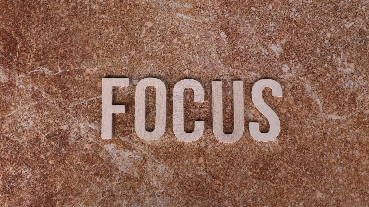 Wooden letters spelling 'FOCUS' on a textured brown surface for emphasis.